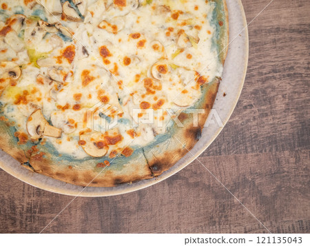 [Ukraine] A whole pizza on a wooden table in a restaurant in eastern Kharkiv 121135043