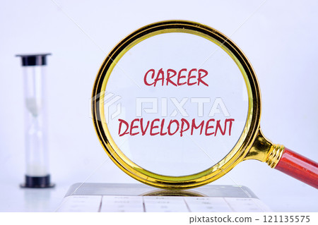 Business concept. The text, words CAREER DEVELOPMENT is written on through a magnifying glass on a calculator with an hourglass next to it Business concept. The text, words CAREER DEVELOPMENT is written on through a magnifying glass on a calculator with an hourglass next to it 121135575