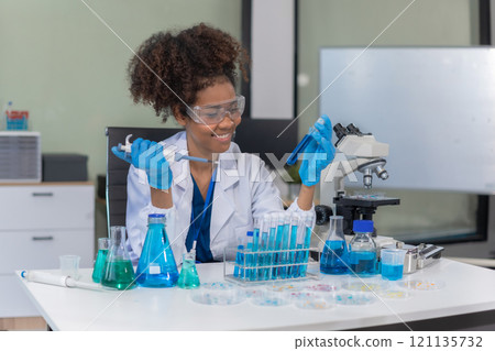 Scientist mixing chemical liquids in the chemistry lab. Researcher working in the chemical laboratory. 121135732