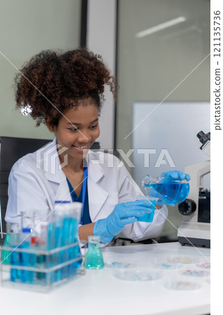 Scientist mixing chemical liquids in the chemistry lab. Researcher working in the chemical laboratory. 121135736