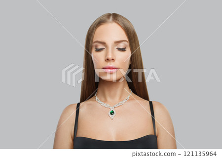 Perfect jewellery model woman wearing stylish gold necklace with green crystal emerald and diamond  121135964
