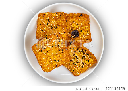 Top view of square shape bars of crispy homemade multigrain rice cracker in white ceramic dish. Top view of square shape bars of crispy homemade multigrain rice cracker in white ceramic dish. 121136159