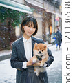 Woman holding a Pomeranian dog in the snow 121136538