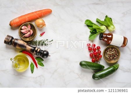 Fresh vegetables and herbs arranged on a marble surface for meal preparation in a cozy kitchen Fresh vegetables and herbs arranged on a marble surface for meal preparation in a cozy kitchen 121136981