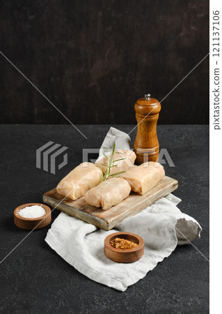 Cabbage spring rolls stuffed with meat ready for cooking on a wooden board with spices Cabbage spring rolls stuffed with meat ready for cooking on a wooden board with spices 121137106