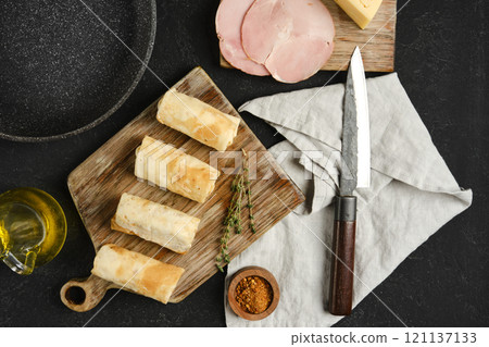 Delicious preparation of savory rolls with ham and cheese on a wooden board Delicious preparation of savory rolls with ham and cheese on a wooden board 121137133