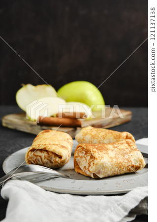 Delicious dessert crepes with apple filling served on a plate Delicious dessert crepes with apple filling served on a plate 121137138