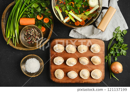 Preparation of fresh dumplings with ingredients and broth on a wooden table Preparation of fresh dumplings with ingredients and broth on a wooden table 121137199