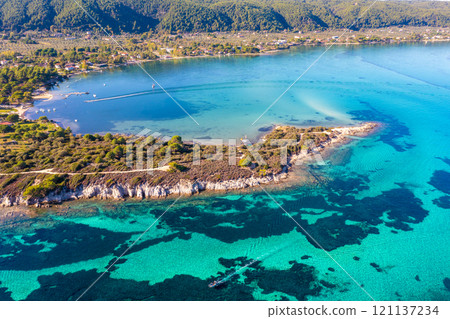 Seascape on a sunny day. Top view of a beautiful bay. Aegean sea texture in Vourvourou, Greece Seascape on a sunny day. Top view of a beautiful bay. Aegean sea texture in Vourvourou, Greece 121137234