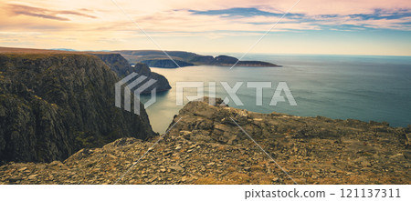 Rocky sea shore with blue cloudy sky. Beautiful nature Norway. Arctic bay. Mageroya island. Nordkapp. Arctic ocean 121137311