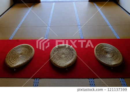 猩紅色地毯上放置一個圓形墊子 121137399