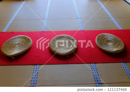 猩紅色地毯上放置一個圓形墊子 121137400