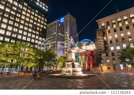 Montreal, Quebec, Canada - August 18 2021 : Night view of Place d'Armes in Old Montreal. Maisonneuve Monument. 121138265