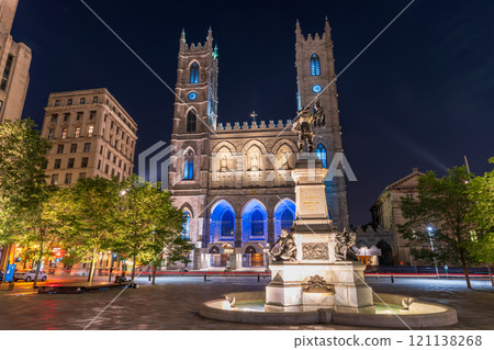 Montreal, Quebec, Canada - August 18 2021 : Night view of Place d'Armes in Old Montreal. Notre-Dame Basilica. Maisonneuve Monument. 121138268