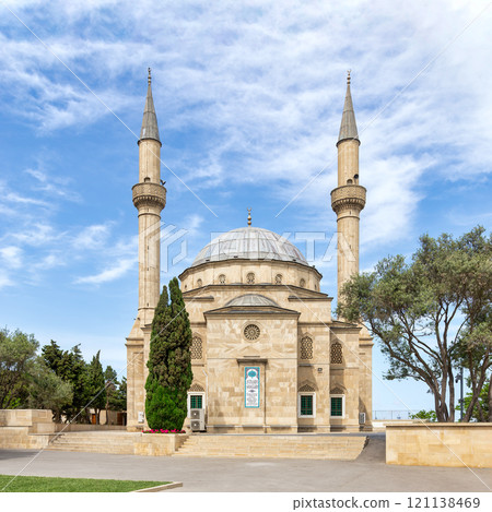 The Shehitler Mosque, a historic mosque with twin minarets in a serene landscape under a cloudy sky in Baku, Azerbaijan The Shehitler Mosque, a historic mosque with twin minarets in a serene landscape under a cloudy sky in Baku, Azerbaijan 121138469
