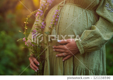 Hands of fairy Pregnant Woman In Wild Forest At Sunset, Golden Hour. Beauty of female body Hands of fairy Pregnant Woman In Wild Forest At Sunset, Golden Hour. Beauty of female body 121138590