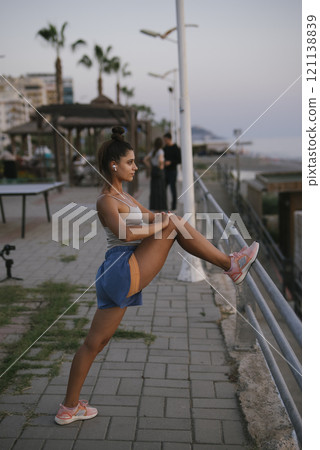 Start your day with an invigorating morning stretch along the picturesque beach path Start your day with an invigorating morning stretch along the picturesque beach path 121138839