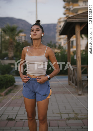 A Young Lady Dressed in Athletic Wear Enjoying the Outdoors in an Urban Environment 121138863