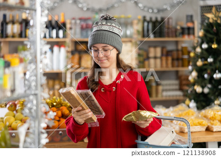 Adolescence girl customer choose consider desserts and sweet snacks. Adolescence girl customer choose consider desserts and sweet snacks. 121138908