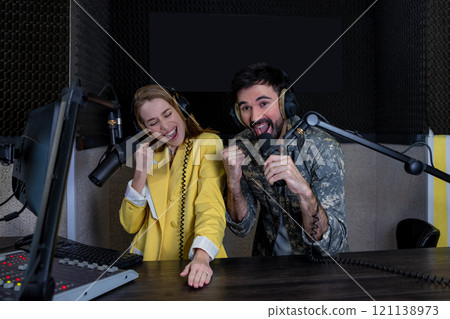 Man and woman presenting in radio station hosting live radio show Man and woman presenting in radio station hosting live radio show 121138973