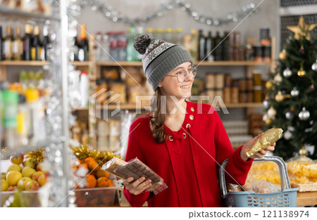 Adolescence girl customer choose consider desserts and sweet snacks. Adolescence girl customer choose consider desserts and sweet snacks. 121138974