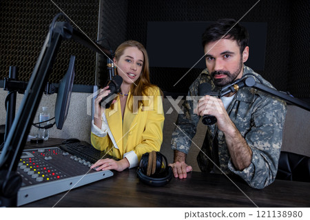 Man and woman presenting in radio station hosting live radio show 121138980