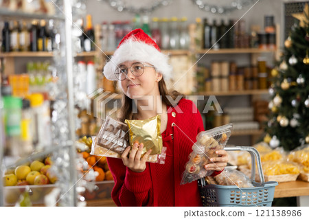 Adolescence girl customer choose consider desserts and sweet snacks. Adolescence girl customer choose consider desserts and sweet snacks. 121138986