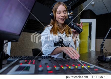 Woman radio host mixing audio at radio station live show Woman radio host mixing audio at radio station live show 121138992