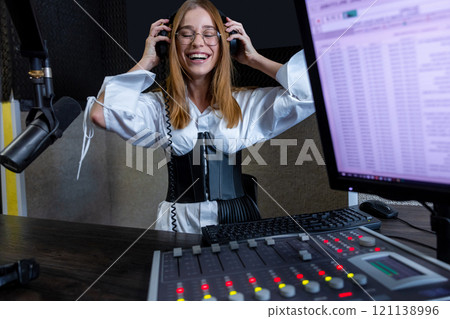 Woman radio host mixing audio at radio station live show Woman radio host mixing audio at radio station live show 121138996