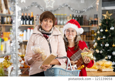 Adolescence girl with mother choose consider desserts and sweet snacks. Adolescence girl with mother choose consider desserts and sweet snacks. 121139058