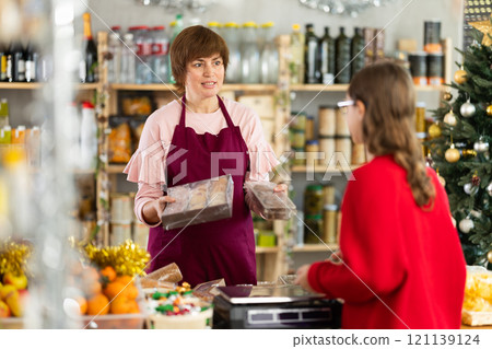 Female employee sells cookies to teen girl Female employee sells cookies to teen girl 121139124