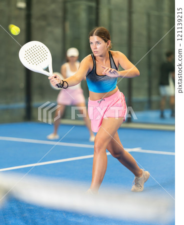 Young and adult women playing doubles tennis 121139215