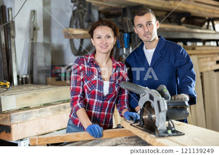 Man and woman posing in oak workshop Man and woman posing in oak workshop 121139249
