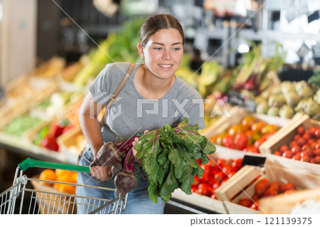 Young girl purchaser buying beetroots in grocery store Young girl purchaser buying beetroots in grocery store 121139375