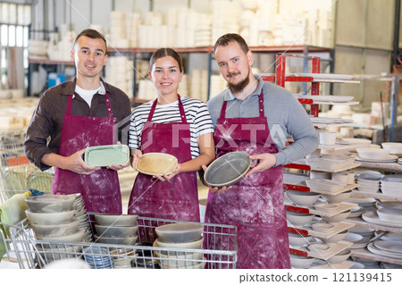 Team of successful professional artisans with handcrafted pottery in workshop 121139415