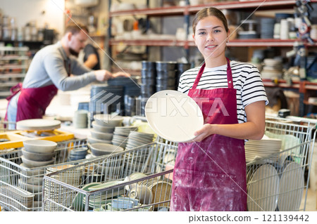 Young woman posing with ceramic dishes 121139442