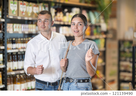 Couple exploring with interest shelves at organic foods store 121139490