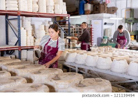 Young woman pouring clay into mold Young woman pouring clay into mold 121139494