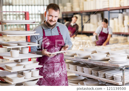 Young man posing with ceramic blanks 121139500