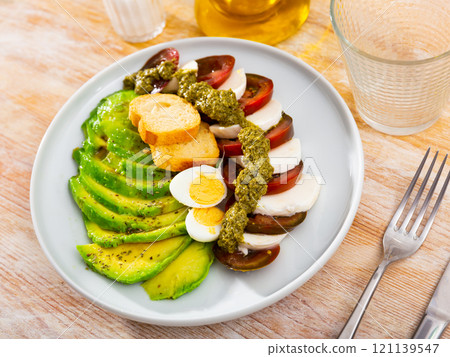 Caprese salad served with avocado and eggs Caprese salad served with avocado and eggs 121139547