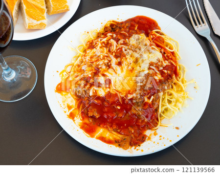 Plate of Italian spaghetti topped with ground beef Bolognese sauce 121139566