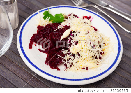 Salad of shredded beets with grated cheese, mayonnaise and greens 121139585