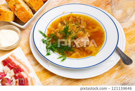 Soup of cabbage with boiled vegetables and pork broth, served in plate Soup of cabbage with boiled vegetables and pork broth, served in plate 121139646