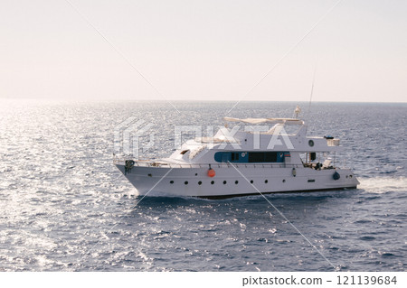 A luxury private motor yacht under way on tropical sea with bow wave 121139684