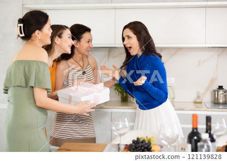 Three women have arrived for birthday celebration and presenting gift to birthday woman 121139828