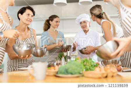 Elderly female visitor has nice conversation with person facing buddy vis-a-vis at culinary courses 121139839