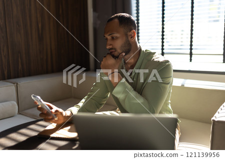 Businessman using laptop computer and smartphone for working online 121139956