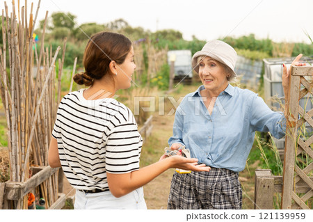 young and mature females, talking at garden 121139959