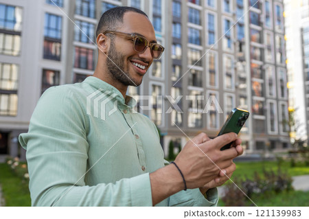 Emotional man browsing website in social media using smartphone on city street 121139983