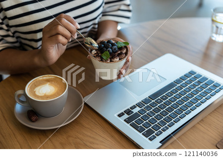 Close up picture of a woman eating tiramisu 121140036